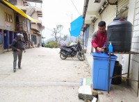 ओखलढुंगा सदरमुकाममा स्थानीयले व्यवस्था गरेको धारामा हात धुँदै सर्वसाधारण